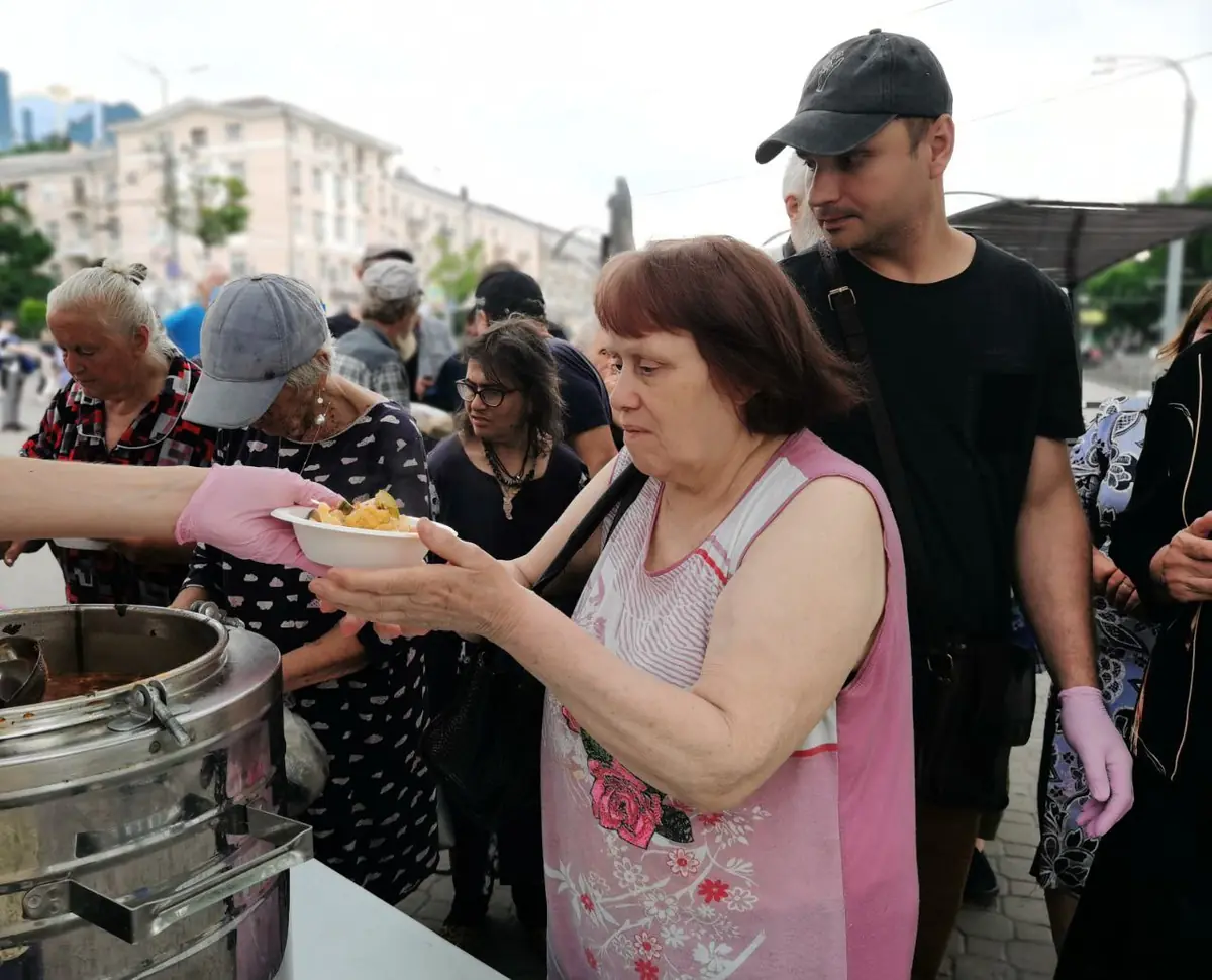 Женщина принимает тарелку с горячим обедом