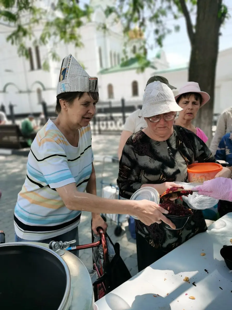 Женщины получают еду в контейнеры на вынос
